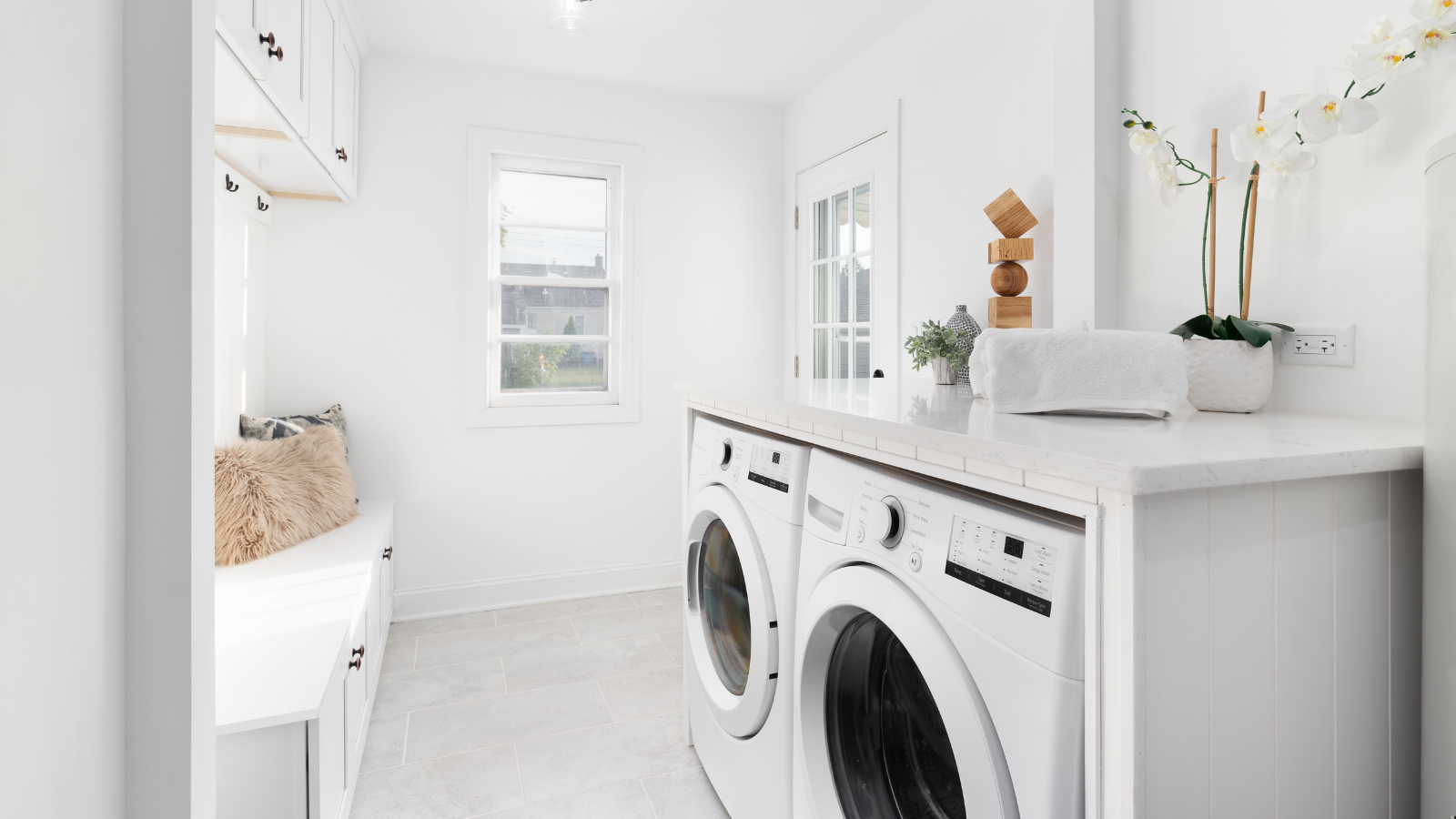 A bright, white laundry room and mud room.