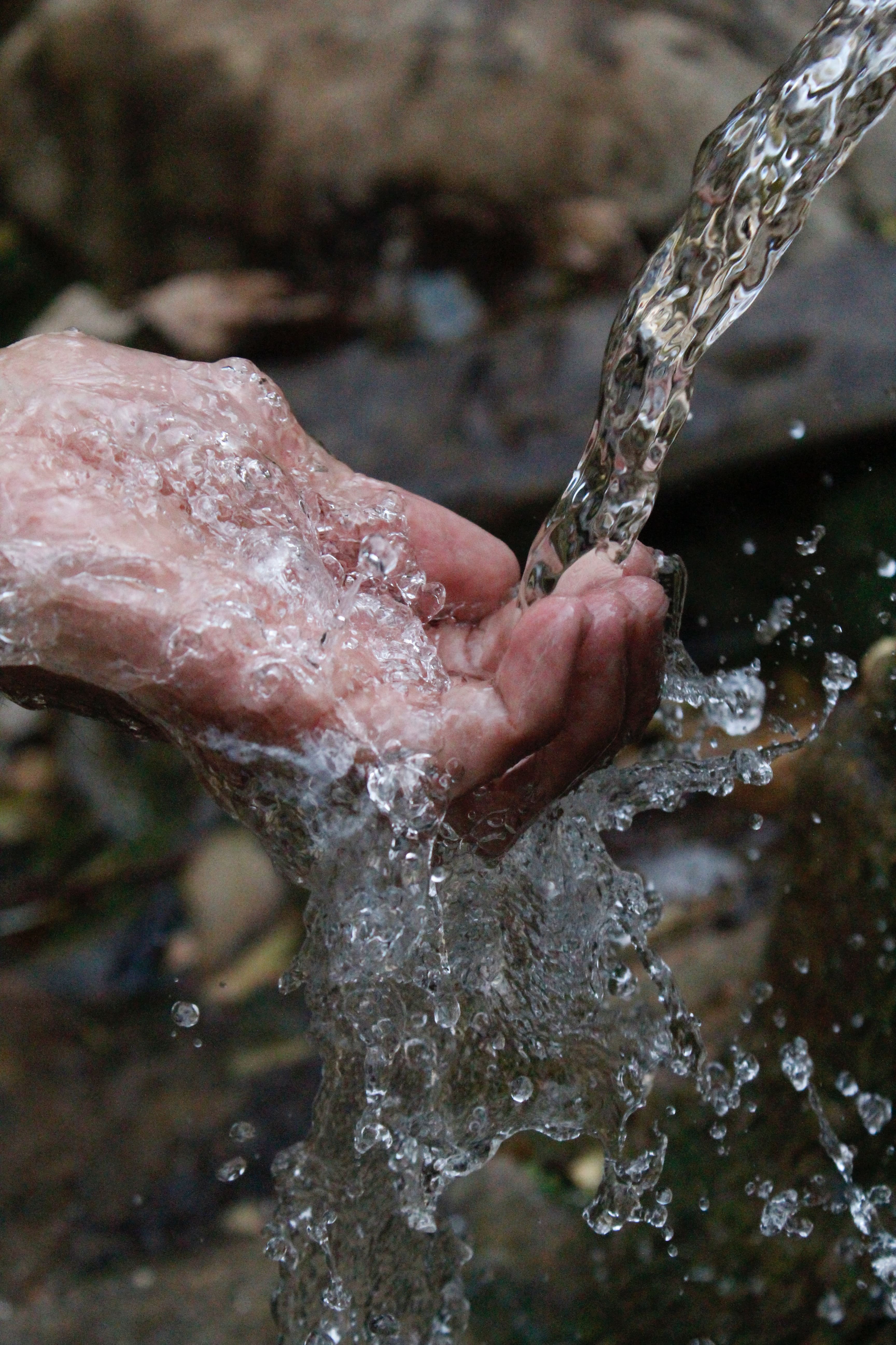 person cleaning hands under water